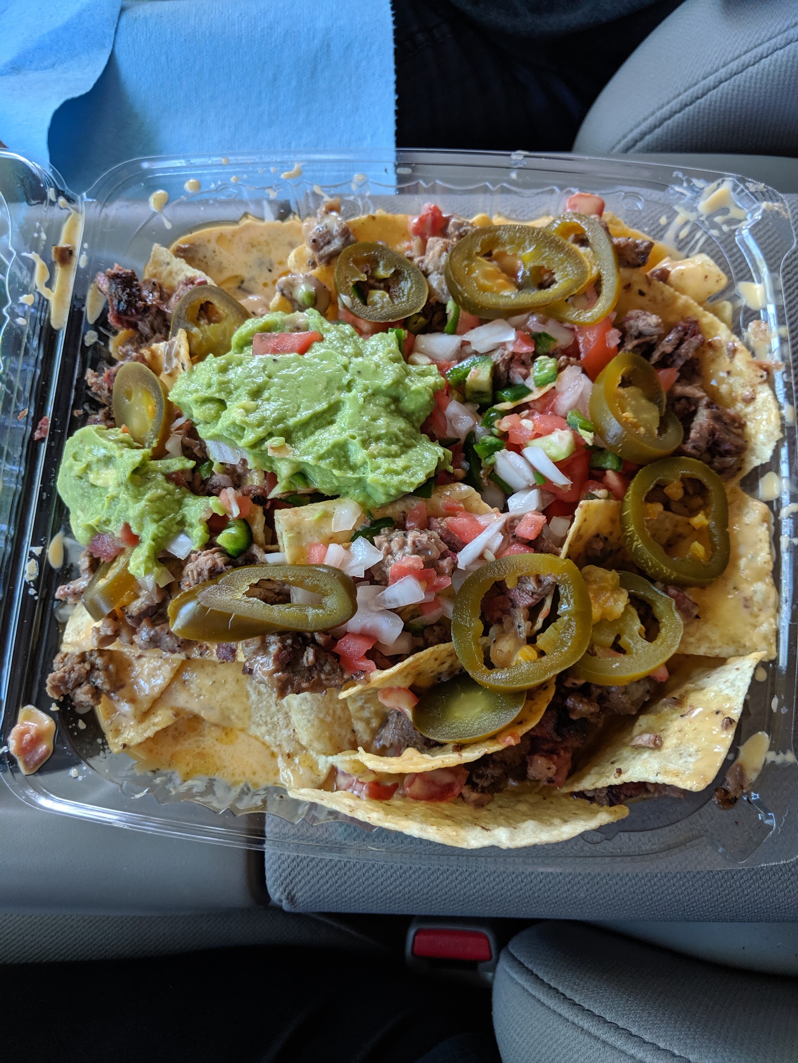 Smoked brisket nachos loaded with pico de gallo, jalapeños and guacamole