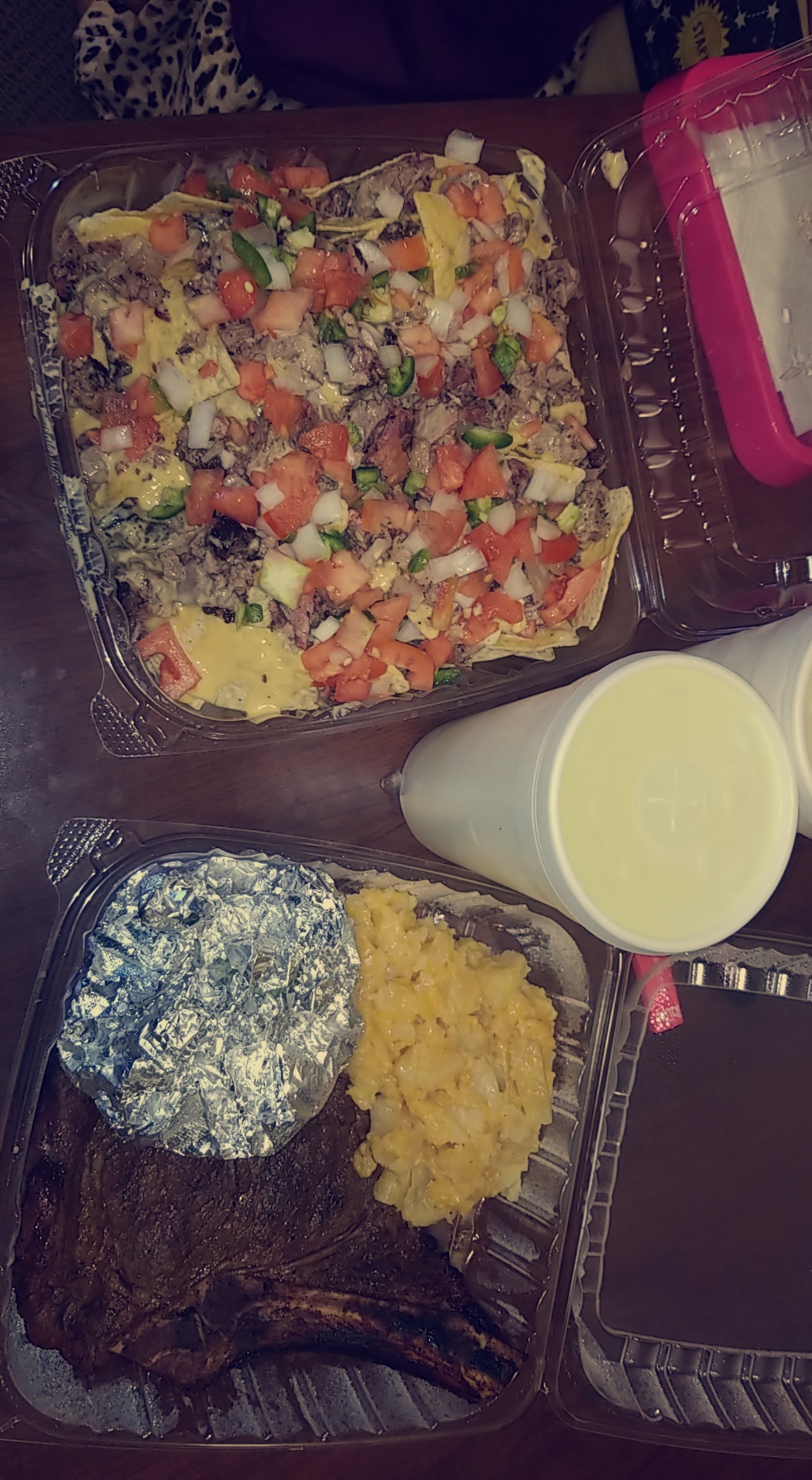 Nachos, steak plate and scrambled eggs spread on the table